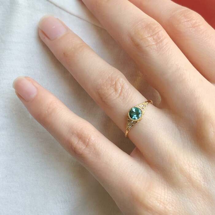 La bague BÉATRICE portée en or jaune 18 carats, tourmaline et saphirs blancs
