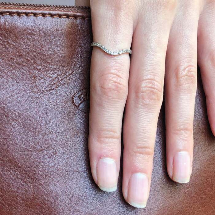la bague Lilibeth courbe en or gris palladié et saphirs blancs portée