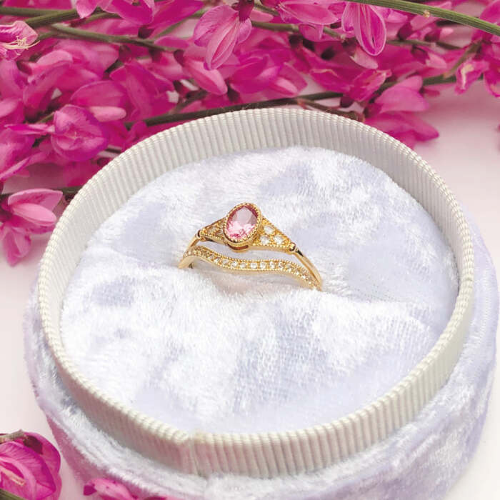 La bague LILIBETH courbe en or jaune 18 carats et saphirs blancs et la bague BÉATRICE sertie d'une tourmaline rose et de saphirs blancs en or jaune 18 carats Fairmined